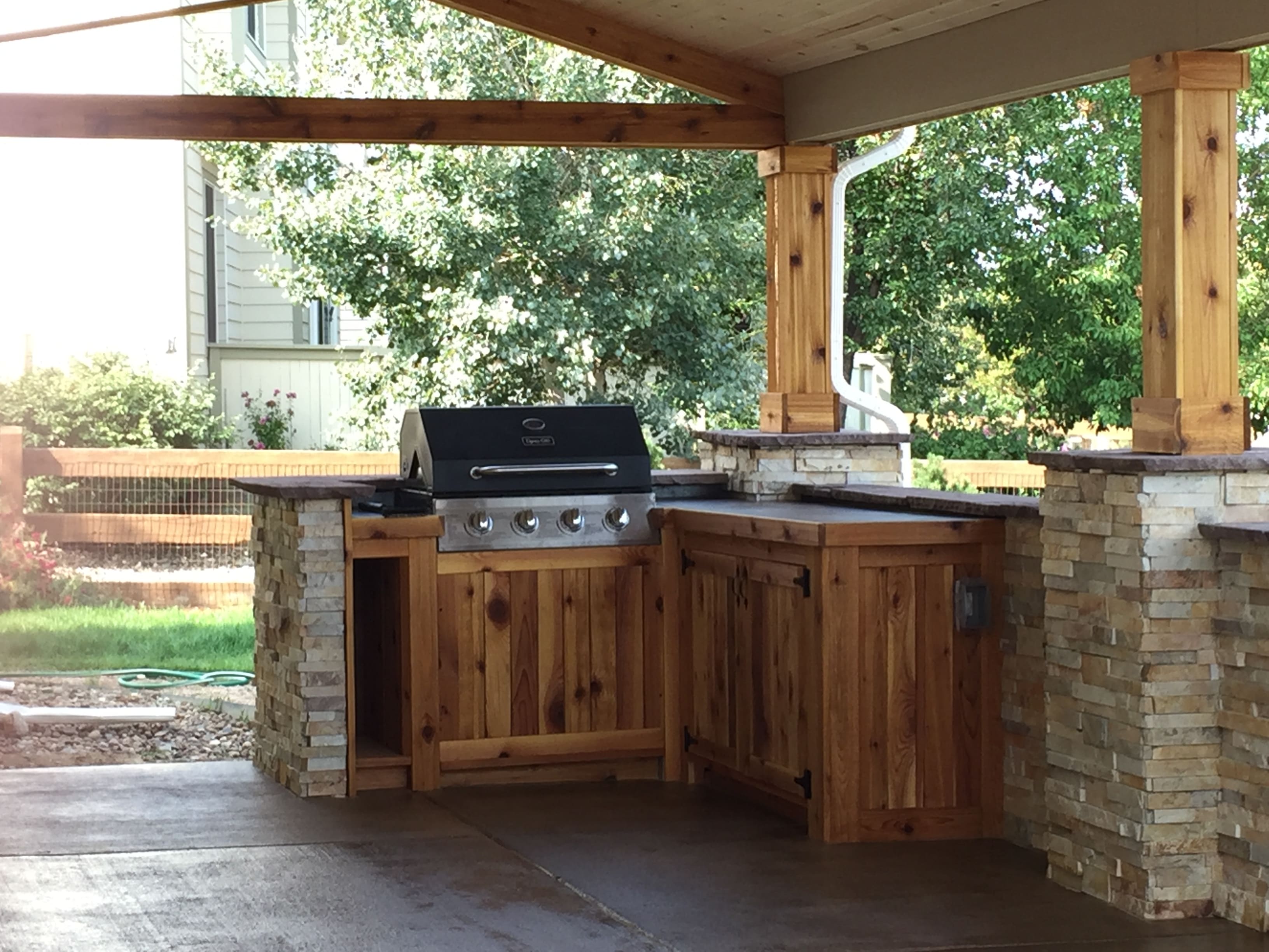 Norstone Aztec XLX Stacked Stone veneer panels used on a large outdoor kitchen with grilling station